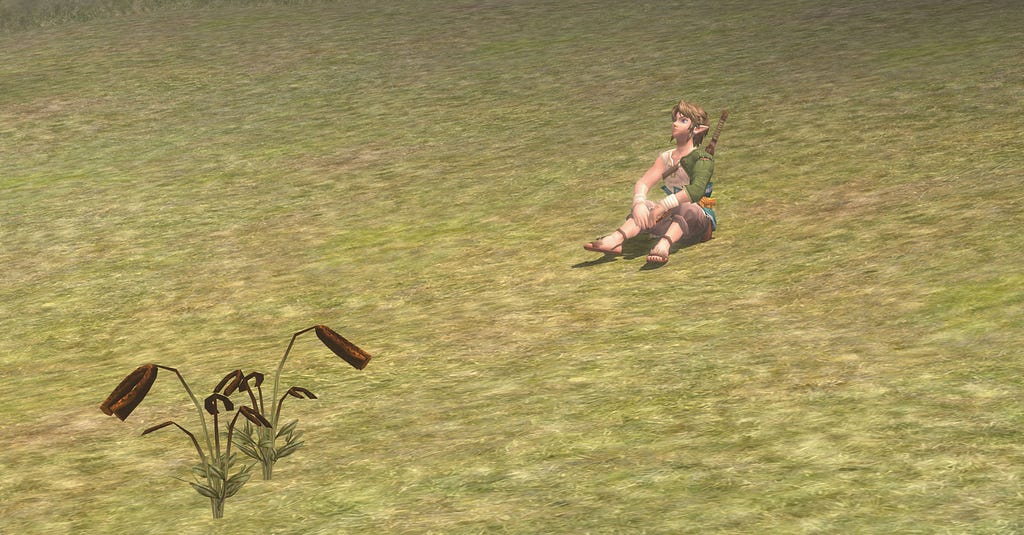 Link sitting in a green field looking up at the sky.
