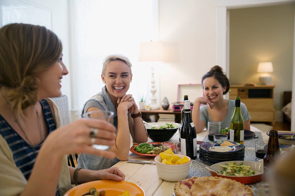 Friends laughing and enjoying dinner party