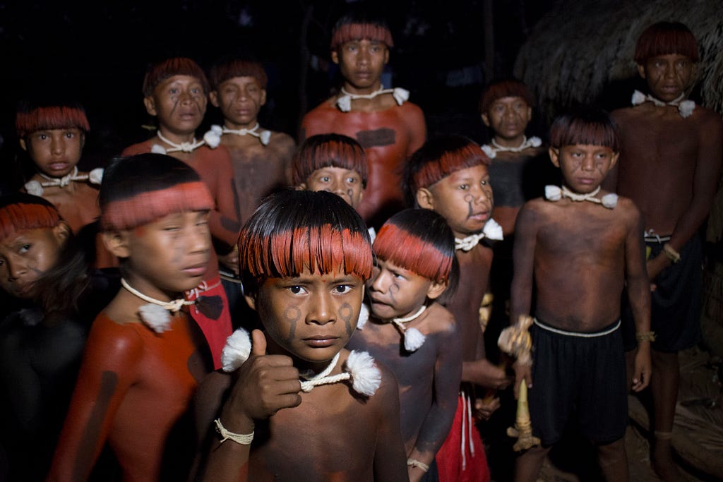 Garotos da tribo Xavantes em pé esperam por ritual