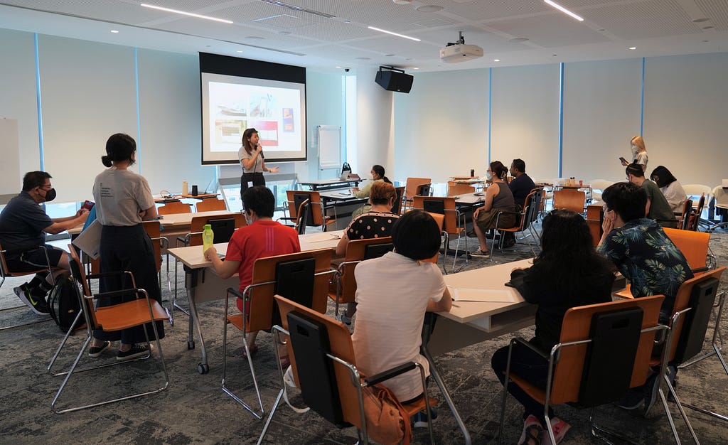 Wendy, head of 55 Minutes Pte Ltd, in front of a room, welcoming workshop participants