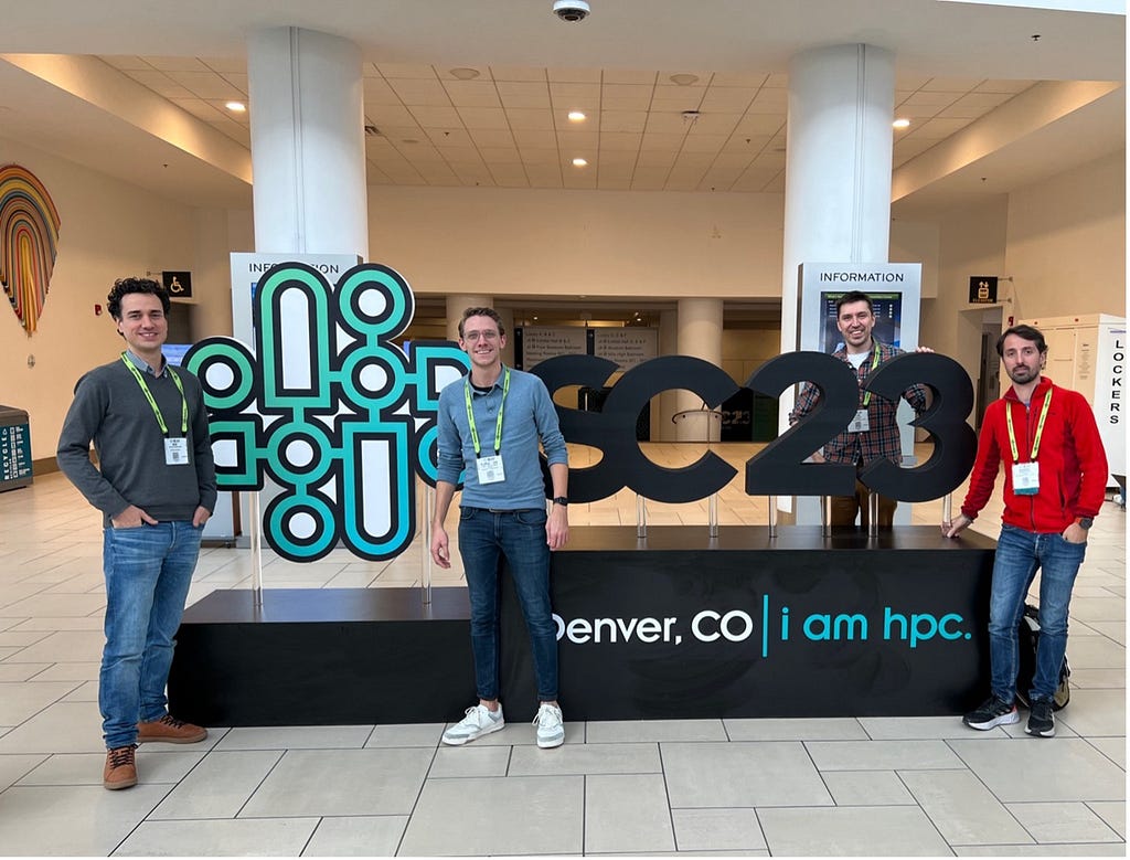 Ben, Floris-Jan, Stijn, and Alessio standing with the SC23 logo at the Colorado Convention Center in Denver. Photo by Floris-Jan Willemsen.