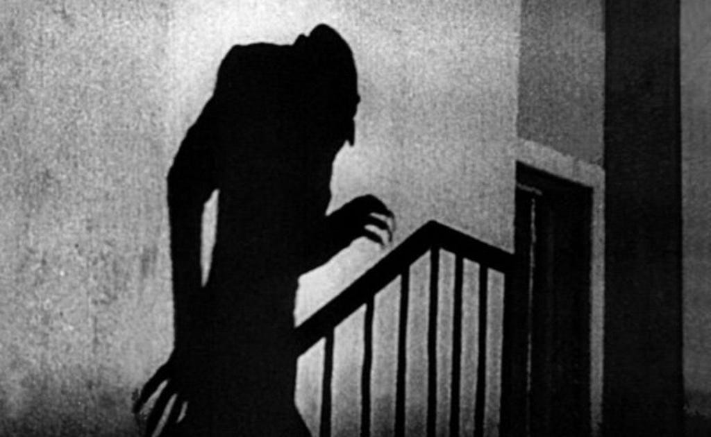 The silhouette of a vampire going up the stairs, with hunchback and long fingernails.