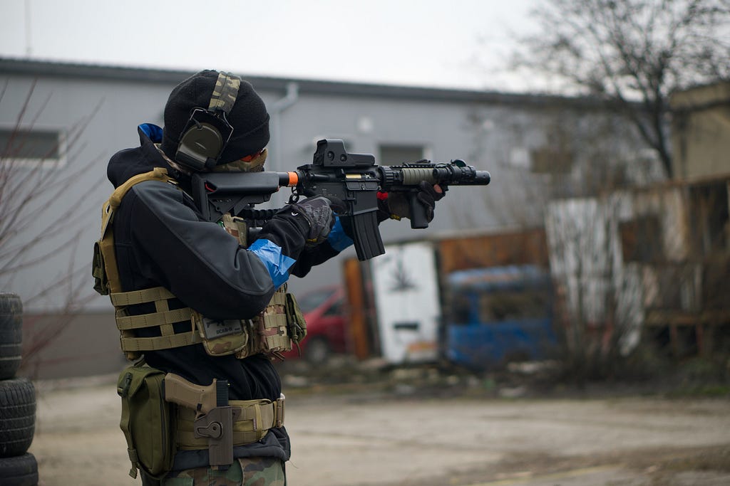 A cop in riot gear with a machine gun, training