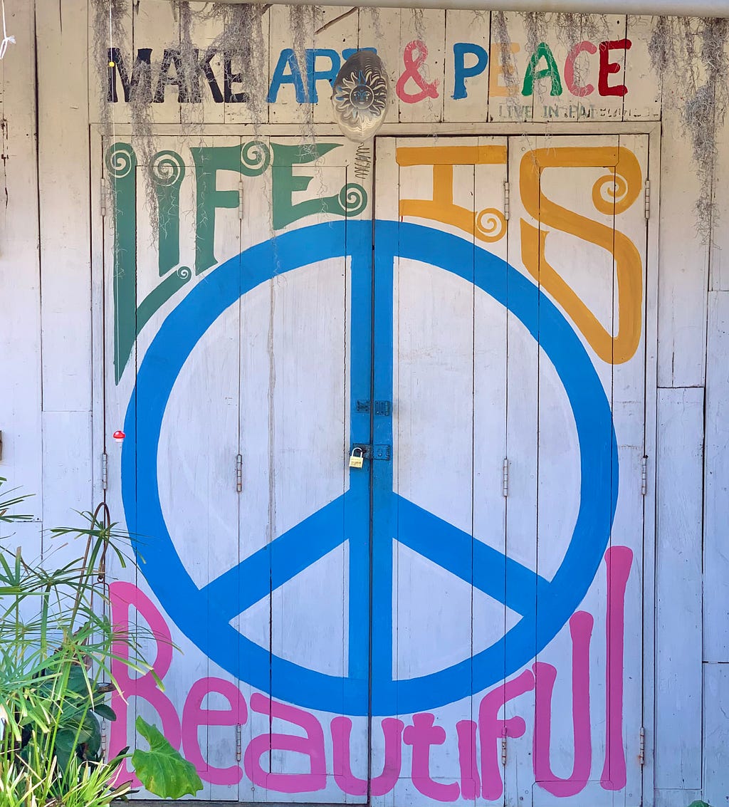 A sign in Pai reading ‘make art and peace, life is beautiful’