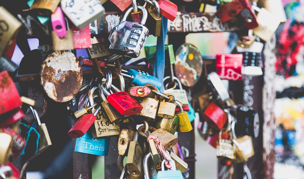 Hundreds of padlocks interlocked together in a cluster.