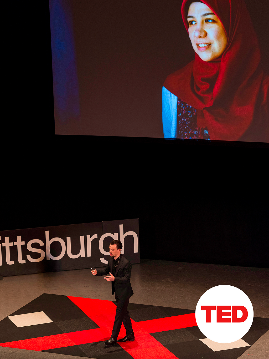 Designer Jack Morgan on-stage giving a TED Talk about Syrian Refugees, and the documentary he made with Justin Merrriman