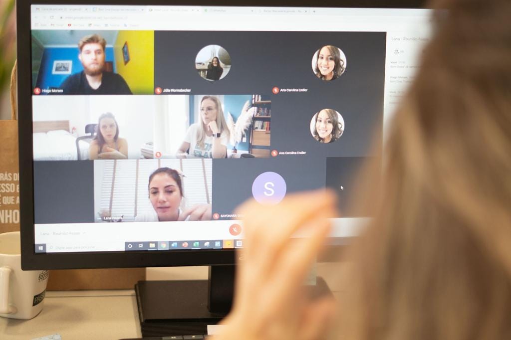 Foto de um monitor de computador preto com uma videochamada do Google Meet. Participam da chamada alguns dos participantes do projeto de reforma da sede: Hiago Moraes, Ana Zuchi, Manoela Gieseler e Lana Piazera.