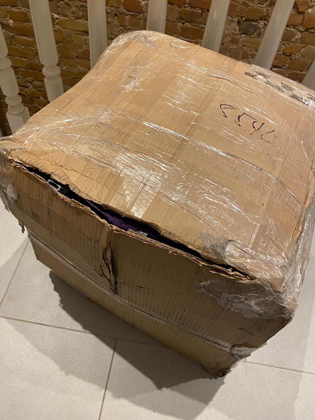 A cardboard box that has been through hell and back. Covered in tape, yet still gaping open, ripped pretty much everywhere. Um, yeah. Obviously tigers attacked it in the UPS holding station as punishment for me not paying the customs brokerage fees.