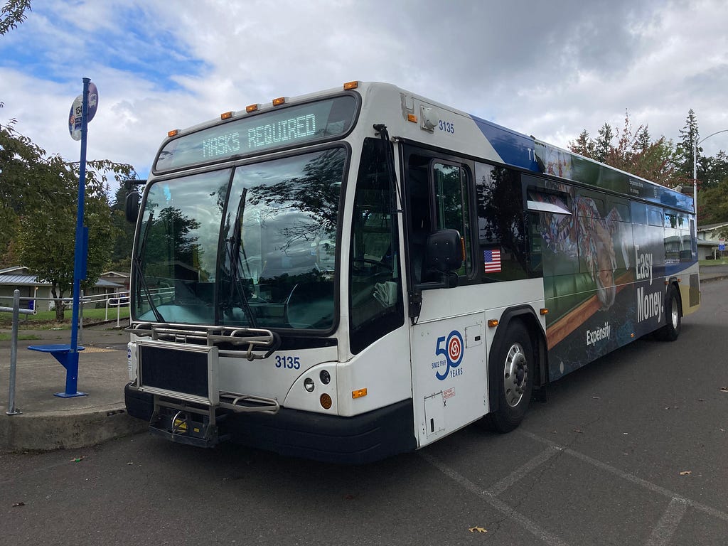 A TriMet bus parked at Clackamas Heights Housing Project in Oregon City with a 50th Anniversary sticker on it.