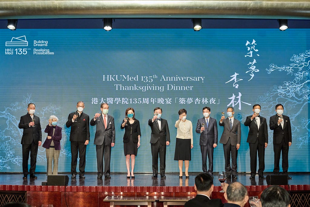 Event attendees on a stage toast with champagne