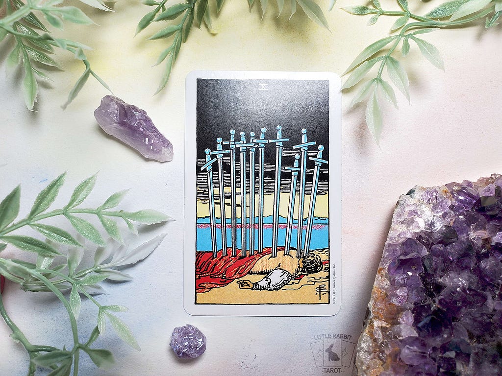 A photo of the Ten of Swords card from the Rider Waite Smith Pocket Edition tarot deck.