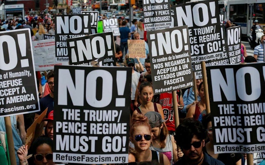Refuse Fascism protesters dawn signs with the group’s message, “Trump and Pence must go!” (Courtesy of Refuse Fascism).