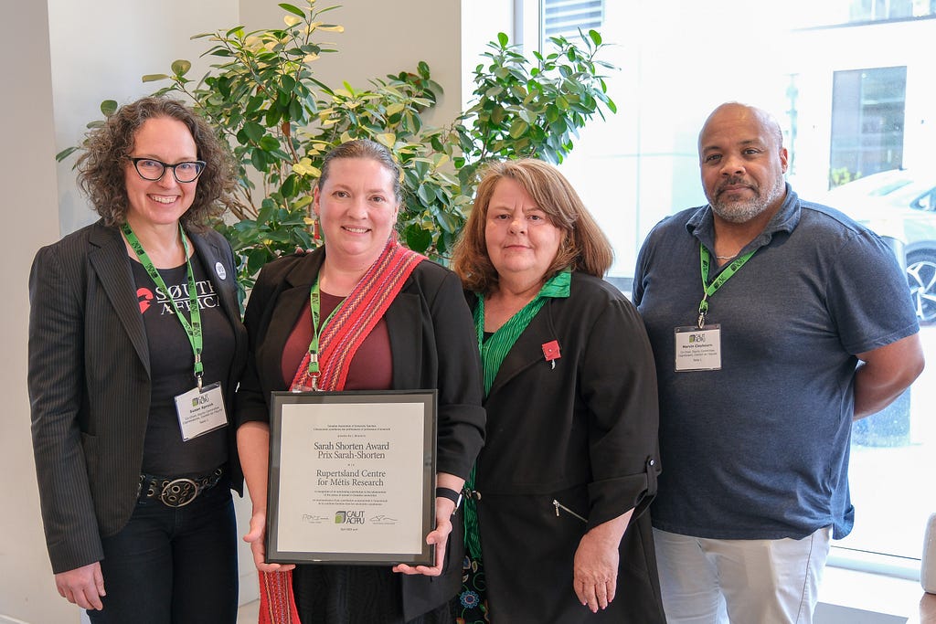 A group photo of 4 people at the award ceremony where the RCMR was presented with the Sarah Shorten award.