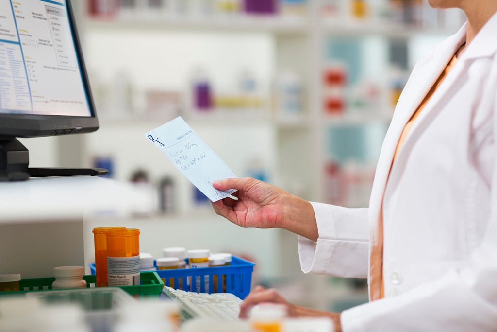 Pharmacist looking at a prescription. Photo by stevecoleimages/Getty Images