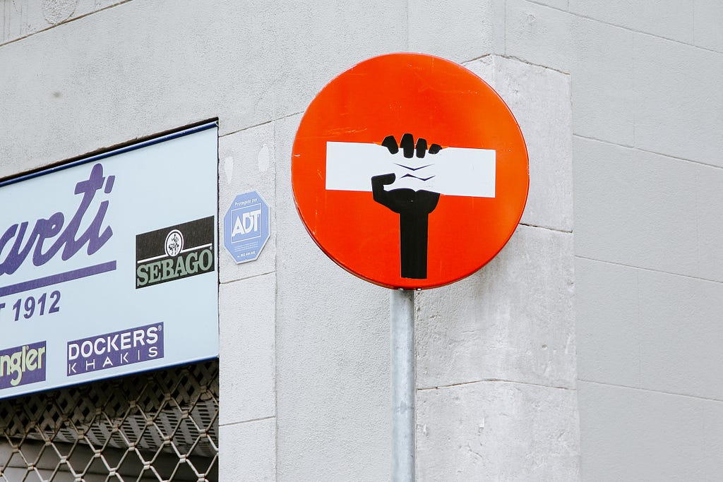 The image of a road sign enhanced by street artists