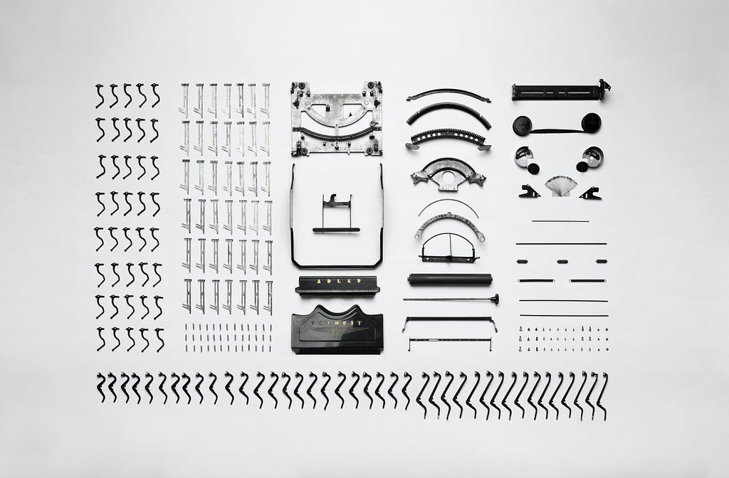 A photograph of all pieces that make an antique typewriter.