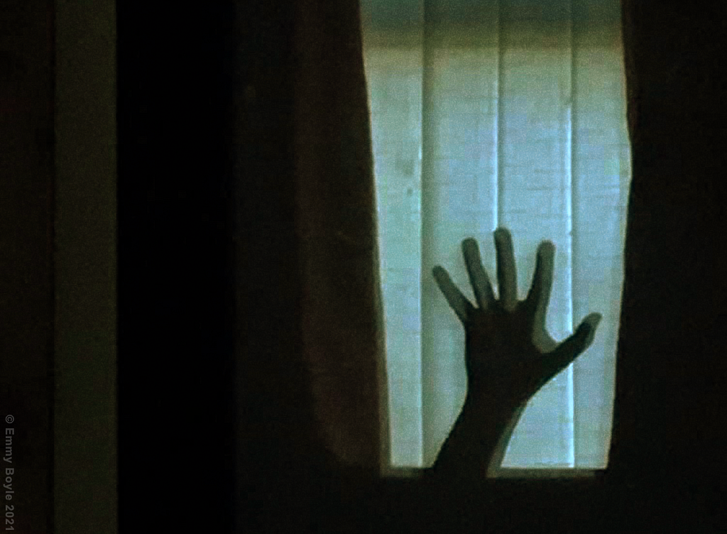 A shadowy hand at a window.