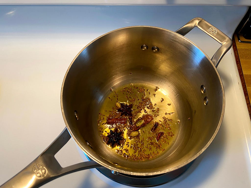 All spices added to the pot: cumin seeds, star anise, cloves, green cardamom and cinnamon.