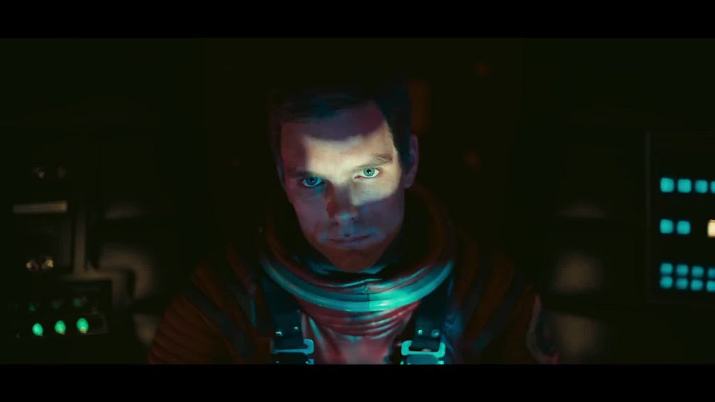 A man in a space suit with a shaft of light across his face.