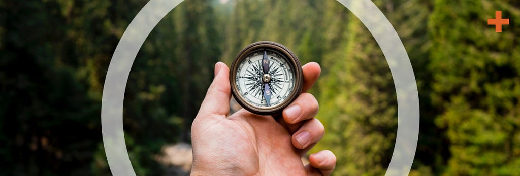 Find your way: a person holding a compass in a pine forest