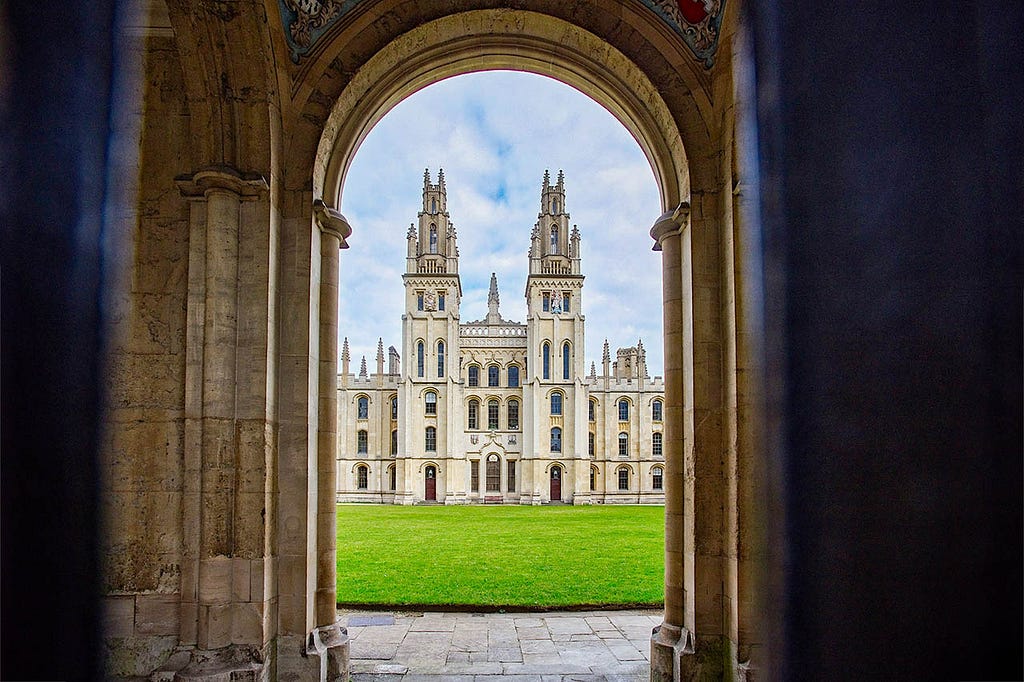 an arched doorway giving way to a two towered yellow stone building