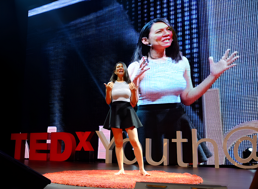 Rozella standing at the TEDxYouth@KL stage, giving a speech on confidence