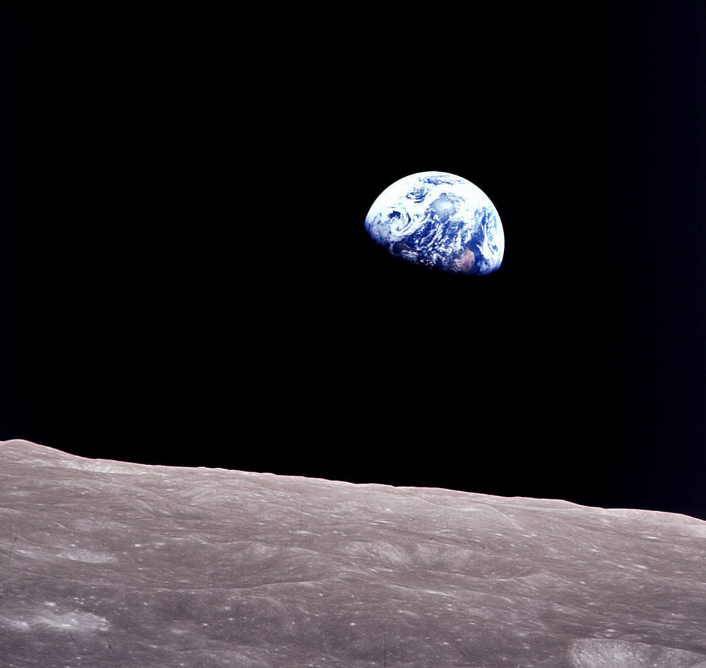 The iconic photo taken aboard Apollo 8 by Bill Anders. In a backdrop of black, it shows the Earth peaking out from beyond the lunar surface.