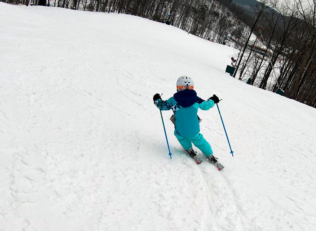 My youngest daughter carving down the mountain. The railroad tracks left by her skis are very clear on the packed snow.