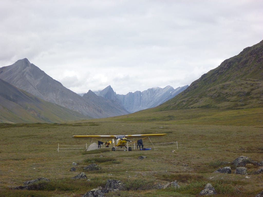 A landed plane in the Alaskan mountains.