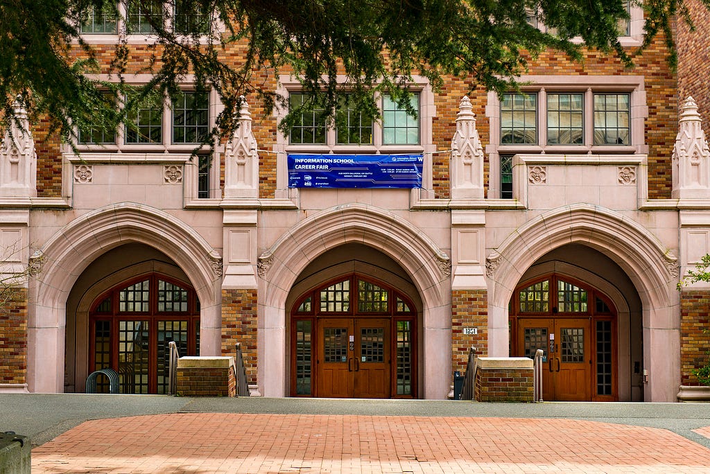 An image of the main entrance of Mary Gates Hall, with a banner “Information School Career Fair”