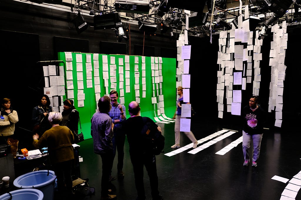 Residents and city staff peruse the rows of forms hanging from the ceiling and the along the ground.