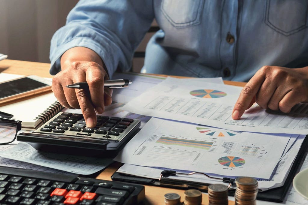 A person using a calculator to determine business expenses.