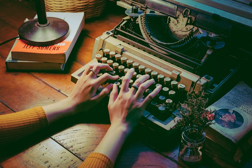 Photo of a writer typing on an old-fashioned typewriter