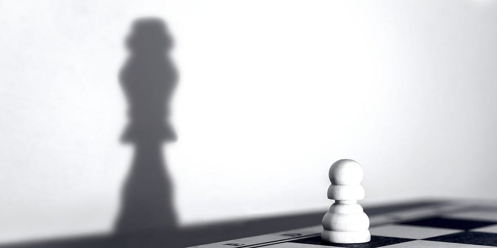 Chess pawn throwing the shadow of a queen