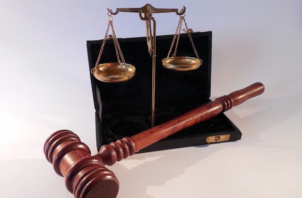 A gavel and the scales of justice in a briefcase