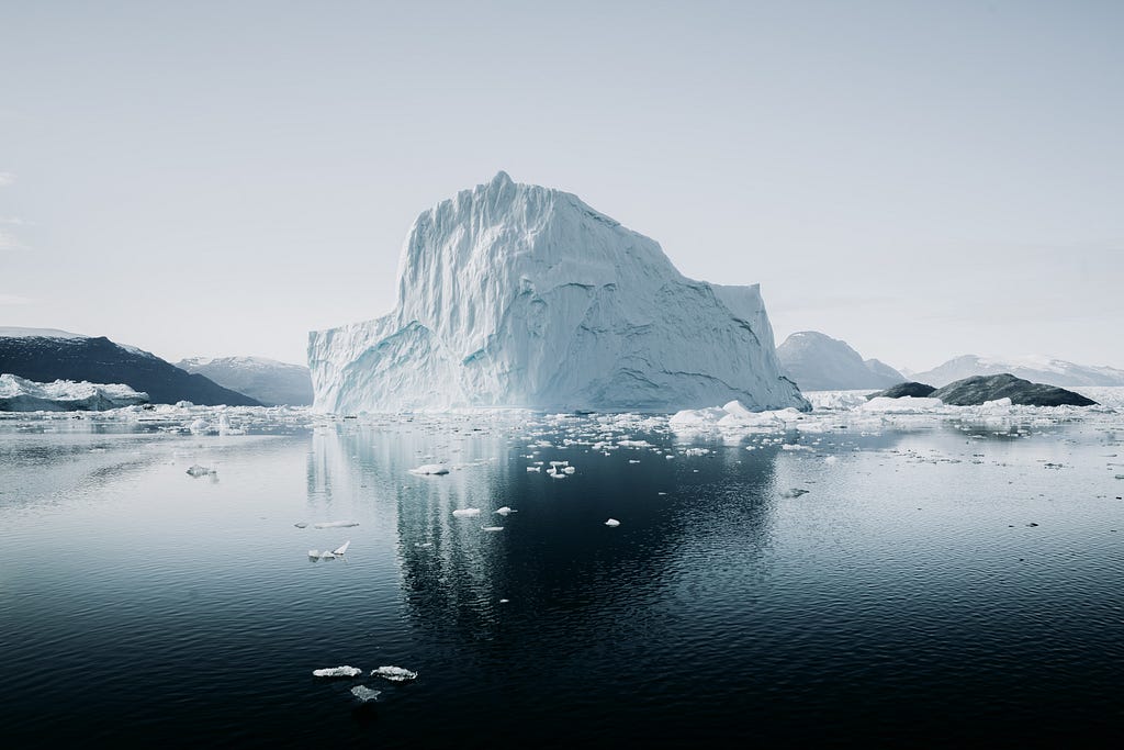A large iceberg in a dark lake of water