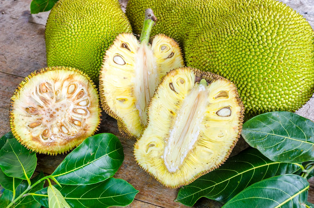 Jackfruit cut in half, showing flesh, white core, and seeds
