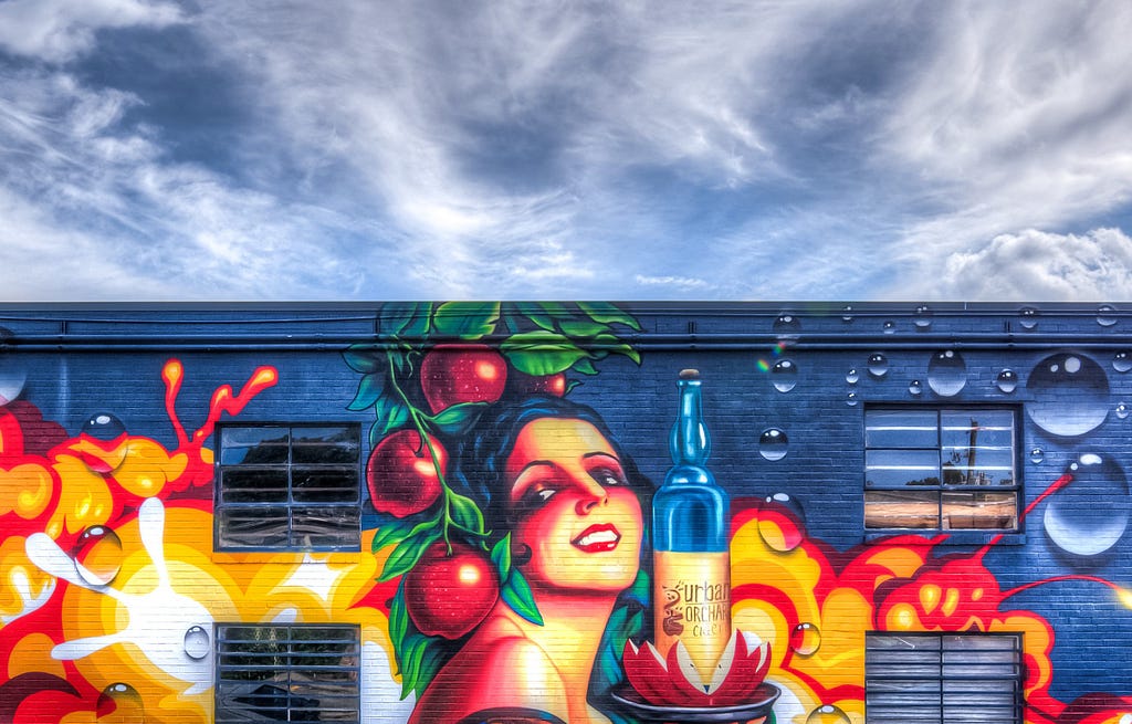 Bright mural of a woman with a cider.