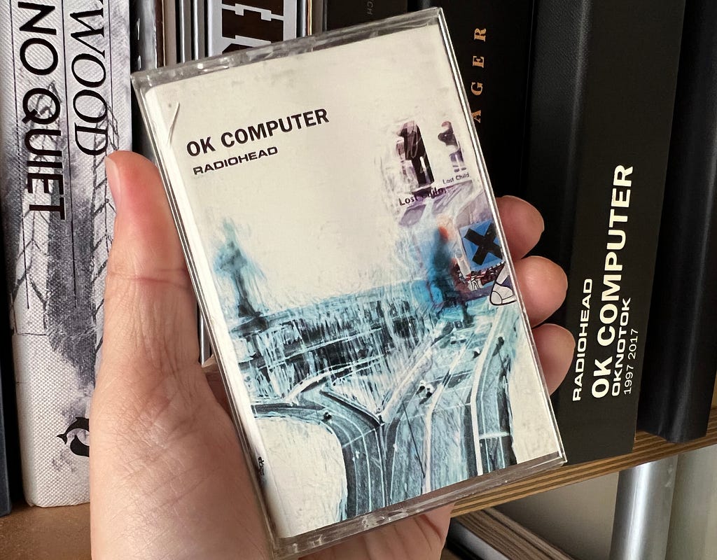 A hand holding a cassette tape of Radiohehead’s OK Computer