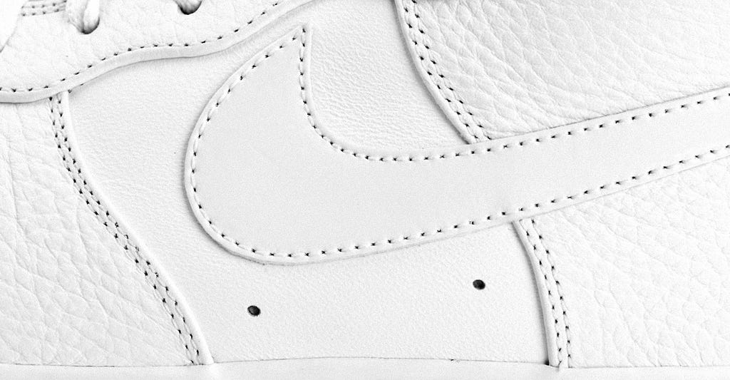 A close up profile crop of a Nike Air Force 1 shoe in all white