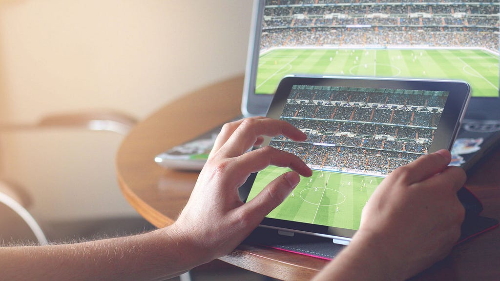 A Laptop and ipad showing synchronized sports streaming