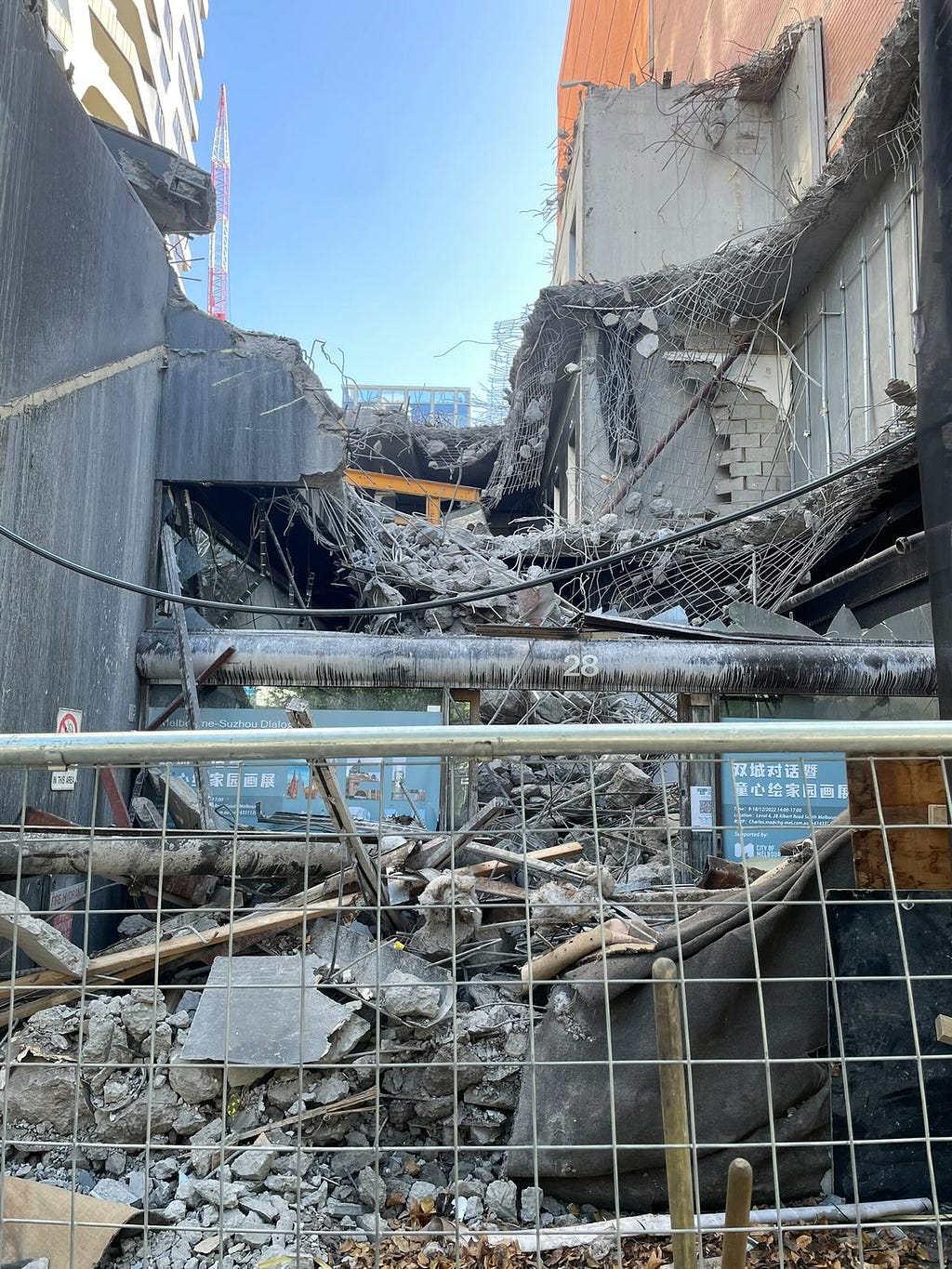Image of a construction site. It is a half demolished concrete building.