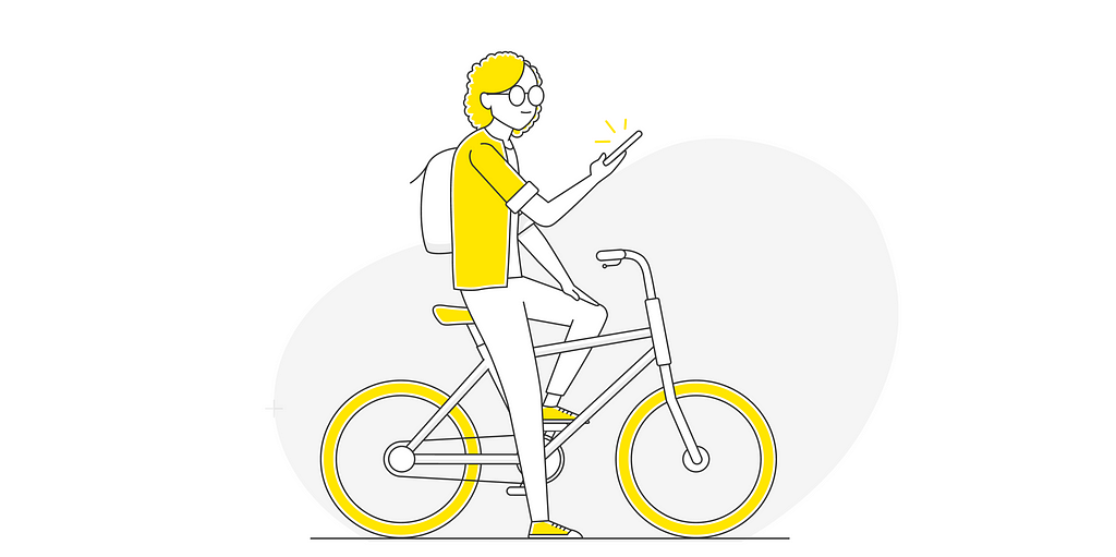 Una mujer en bicicleta mira su teléfono celular.