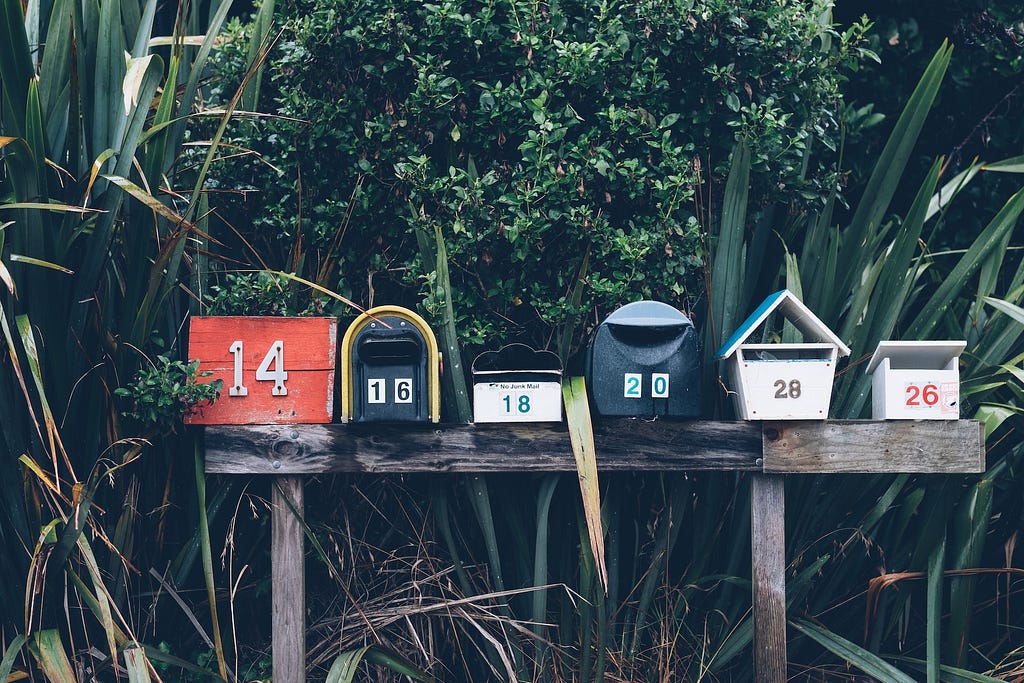 A collection of outdoor mailboxes lined up, each one different from the others.