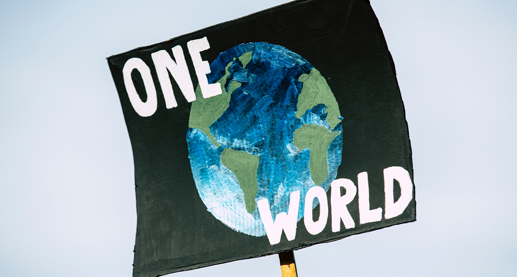 a sign that says “one world” over a globe pictured on black background