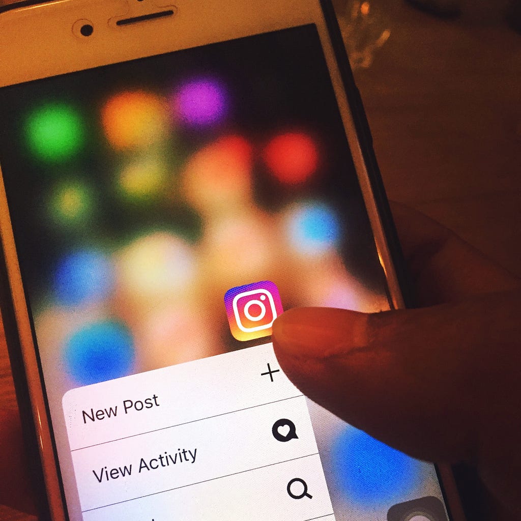 A person using their smartphone to create a new post on Instagram.