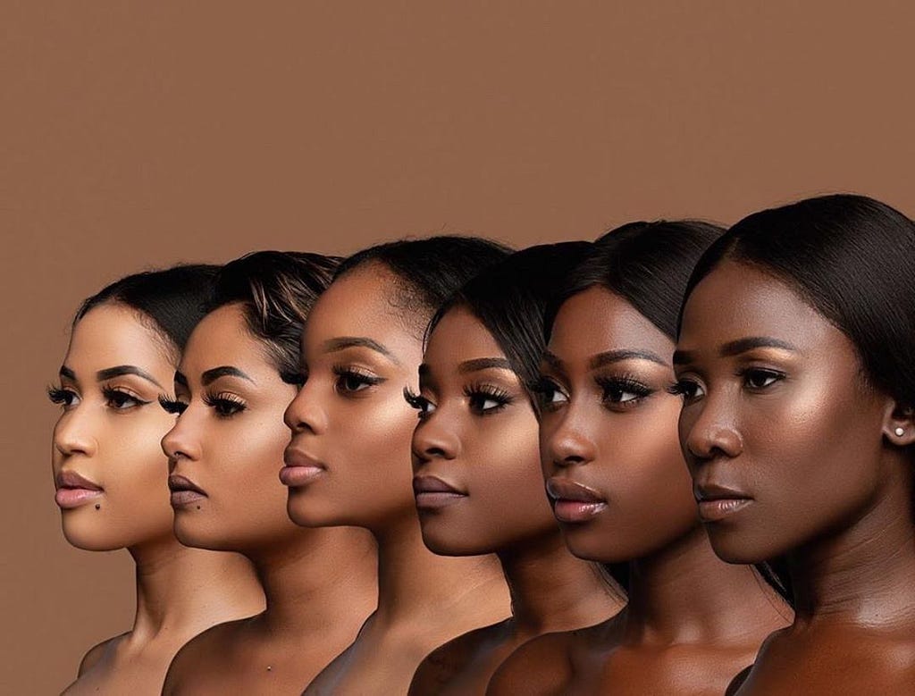 6 Black women of different shades in front of a brown background