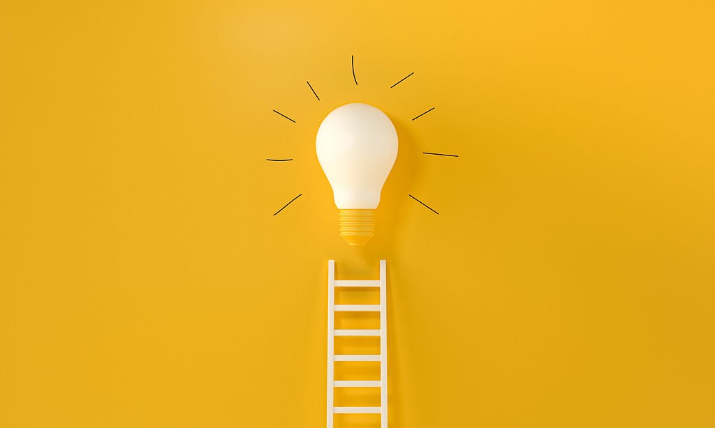 Idea bulb on yellow background with a small stair representing steps