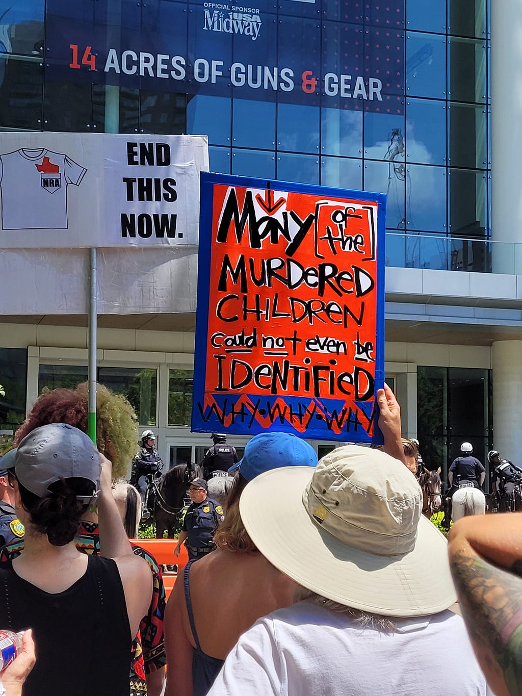 Anti gun violence activists protest outside an NRA convention in Houston and raise signs reading “End This Now” and “Many of the Murdered Children could not even be Identified.”