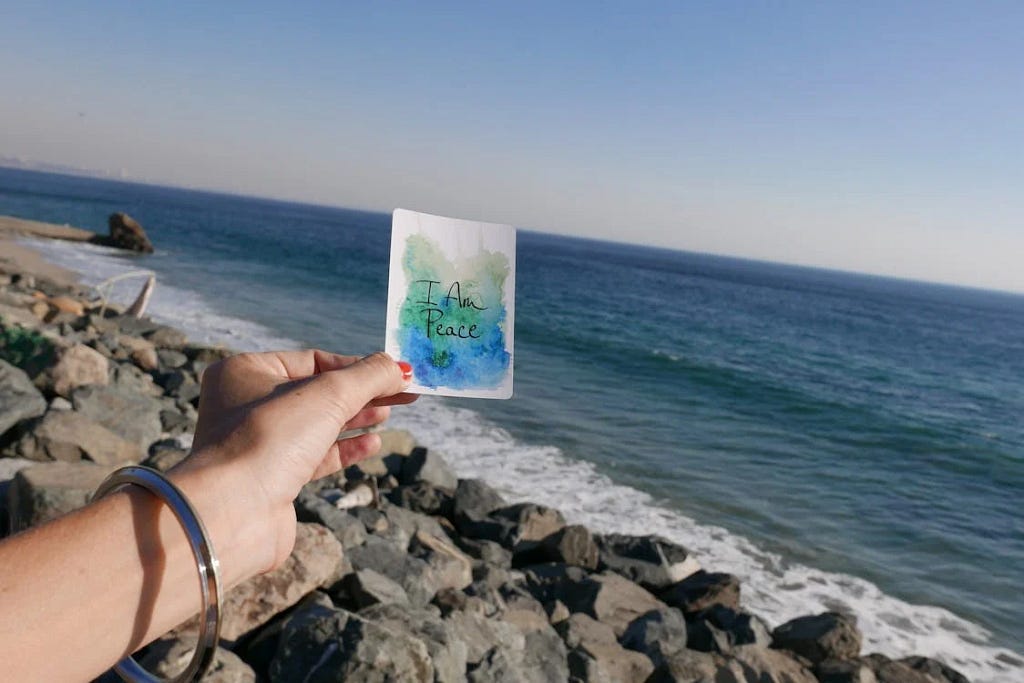 girl carrying a postcard with I am peace in the direction of the sea